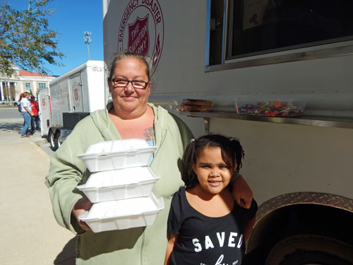 Jolynn and her daughter receive food from a Salvation Army canteen