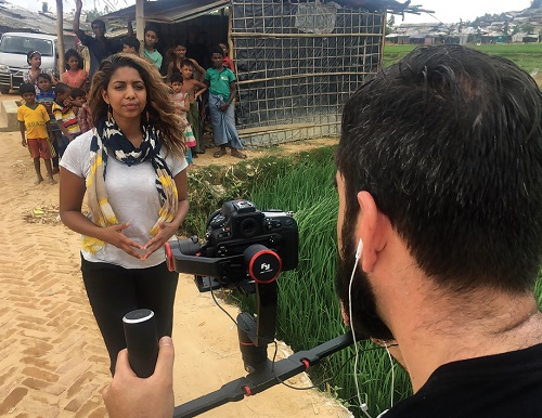A cameraman films Molly Thomas as she reports from a refugee camp in Bangladesh