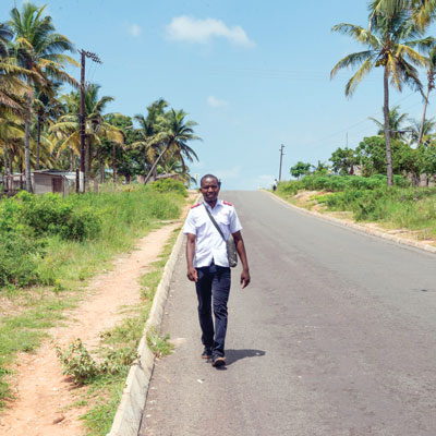 A man in a Salvation Army uniform walks down an empty road