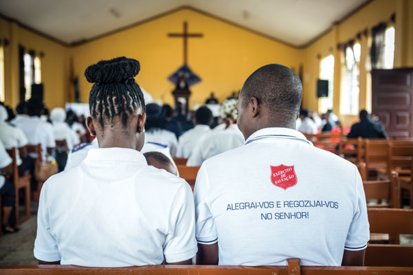 A woman and a man sit facing the front of a church