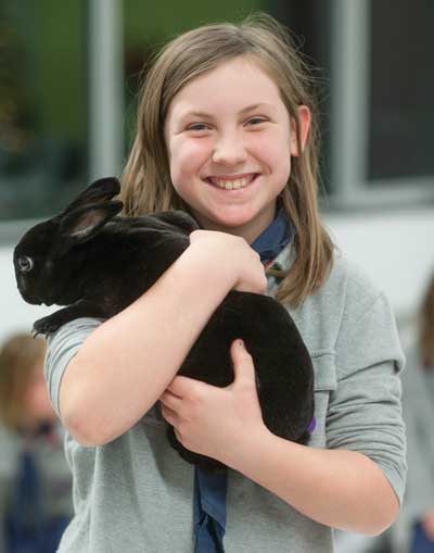 Cub Scout Hannah Larsh meets a rabbit during a visit from Zoo to You