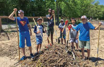 The Scouts rake debris from the beach at Jackson’s Point Camp, Ont., as part of a weekend service project