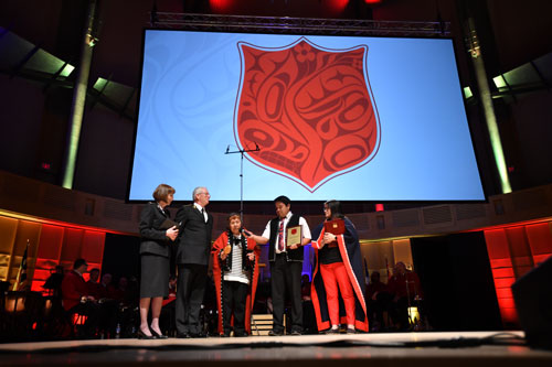 The Gitxsan Shield is displayed as Simogyet (Chief) Axigigii sings