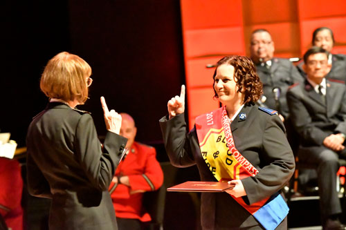 Commissioner Susan McMillan and Cadet Angela Kerr face each other and give the Salvation Army salute