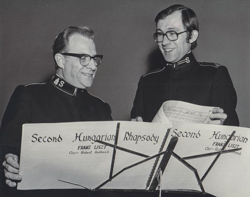 Then Captain Robert Redhead poses with Commissioner Arnold Brown by a pair of music stands