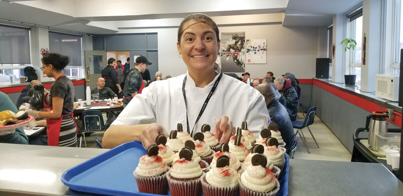 Freedom Adams, food services manager at the Centre of Hope, serves dessert at the Winter Feast