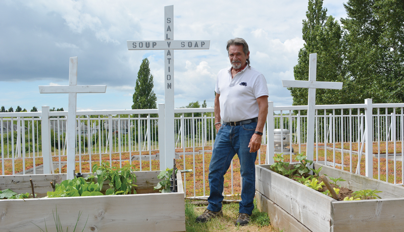 Jean stands in front of his garden