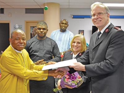 Solomon presents a card and flowers from the church’s African members to Mjrs Donna and Royal Senter 