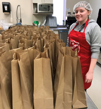 Caitlyn Cumbers prepares brown paper bag food hampers