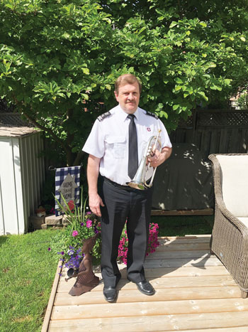 Chris Pugh holds his flugelhorn in uniform