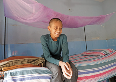 Photo of young boy showing his mosquito net
