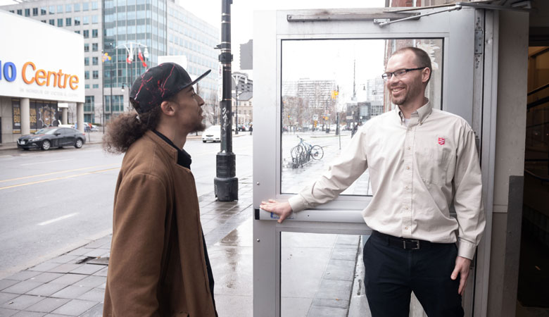 An employee welcomes a neighbour in need to a Salvation Army shelter in Hamilton, Ont.