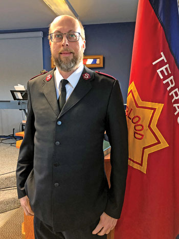 Lieutenant Rick Apperson, pictured next to a Salvation Army flag