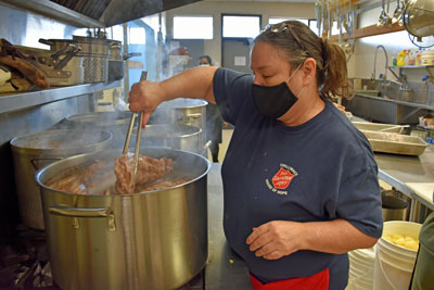 A woman cooks food over a stove