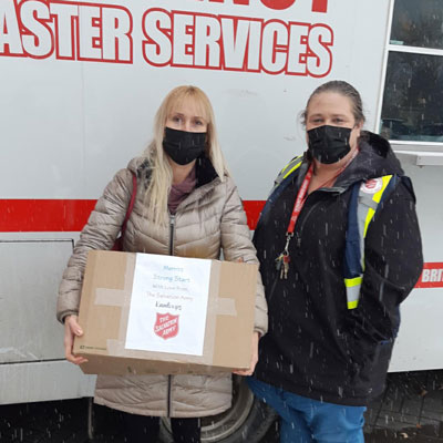 Ewa Olguin holds a box of supplies from The Salvation Army