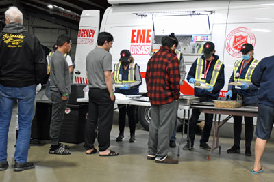 People line up to receive dinner from a Salvation Army canteen truck