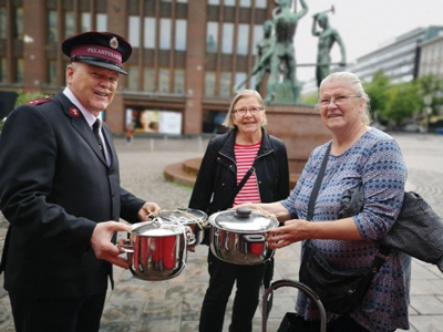 Photo of Major Hannu Lindholm receiving a donation of cooking pots