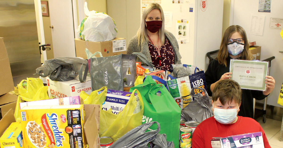 Raelyn Drew (back, right) drops off a donation of food