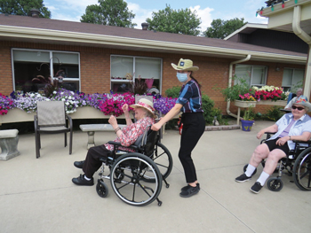 A staff pushes a resident in a whellchair