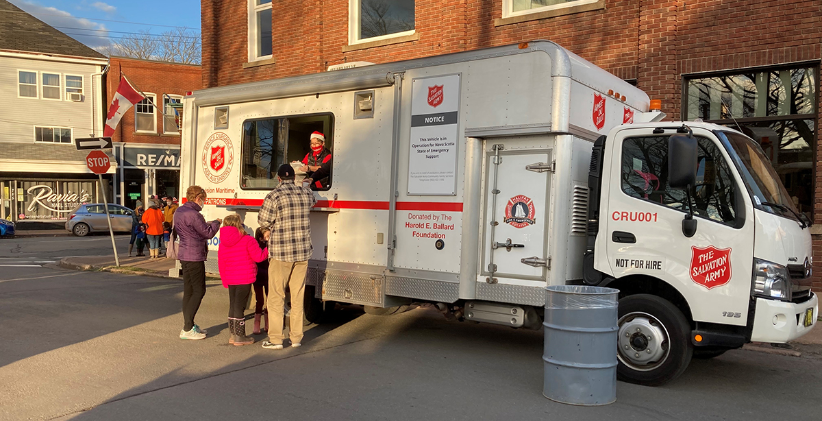 Volunteers from The Salvation Army in Truro, N.S., distribute cookies during a stationary Christmas parade