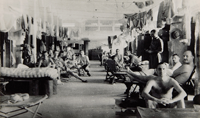Prisoners of war in Changi, sitting and standing, facing the camera