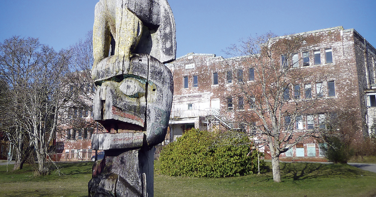 A totem pole stands outside a former Indian residential school in Alert Bay, B.C.