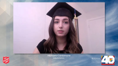 A graduate wearing a cap speaks during a virtual ceremony