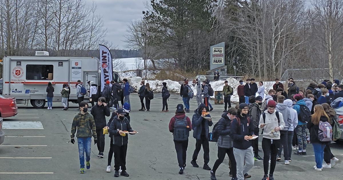 Students gather in the parking lot of the corps for a free pizza lunch