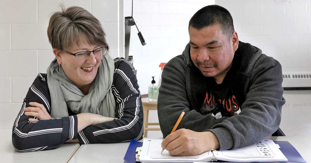 A student learns to read and write at a community-based adult literacy program