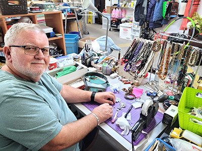 Mario Spitale prices jewelry for sale at the Army’s thrift store in Whitby, Ont.