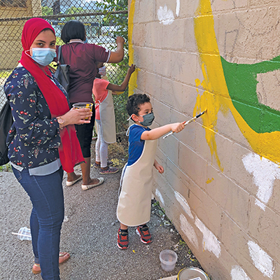 Youth from the Empowerment Squared community centre take part in painting the mural