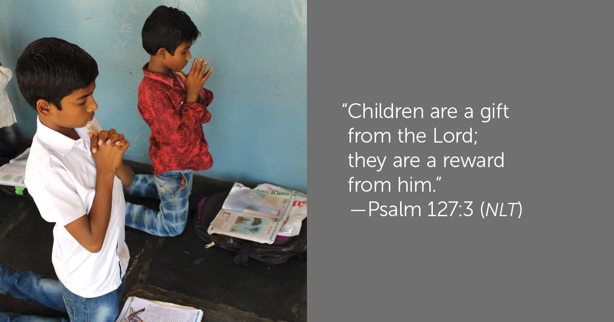 Photo of two young boys praying 