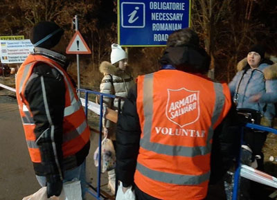 Salvation Army workers speak with refugees at a Romanian border crossing