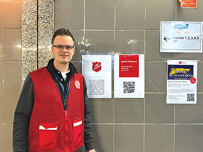  In Medyka, at the Polish-Ukrainian border, Pitcher hangs posters sharing contact information for Salvation Army locations in Ukraine and surrounding areas