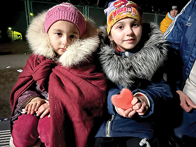 Children bundle up to wait in line and receive assistance at the Medyka border
