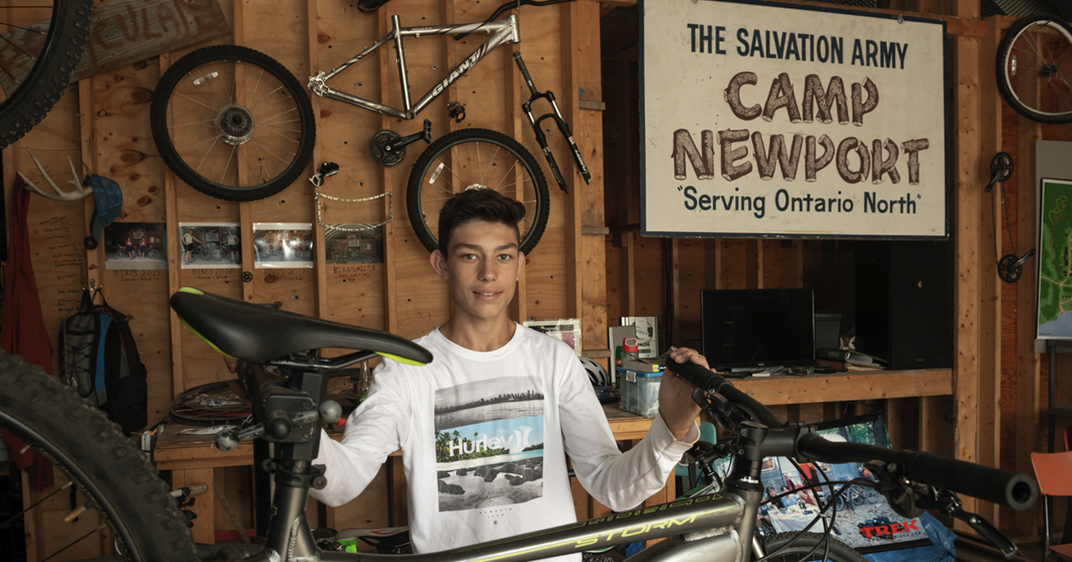 A camper works on a bike at The Salvation Army's Camp Newport