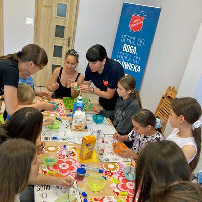Children and adults sit around a table making crafts