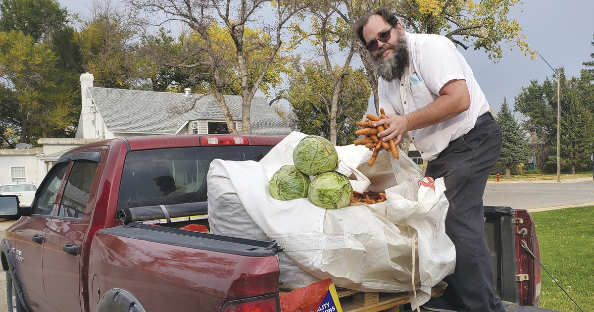 Major Ed Dean unloads a large donation of carrots and cabbage from a truck