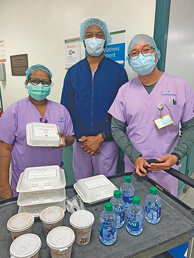Three health-care workers receive meals and water from The Salvation Army