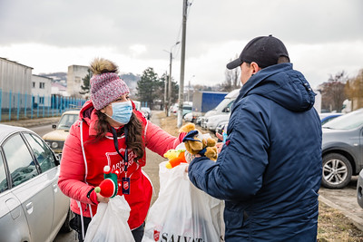 A Salvation Army worker hands a care package to a refugee