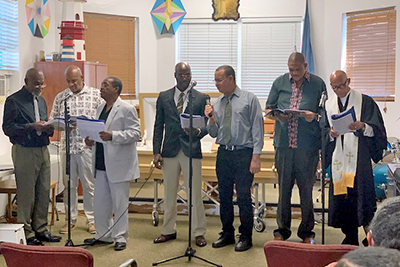 Residents sing at a mock funeral service