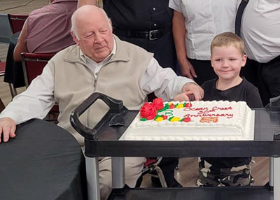 Ed Charlton and Asher Ness, the oldest and youngest members of the church, lead the celebratory cake cutting