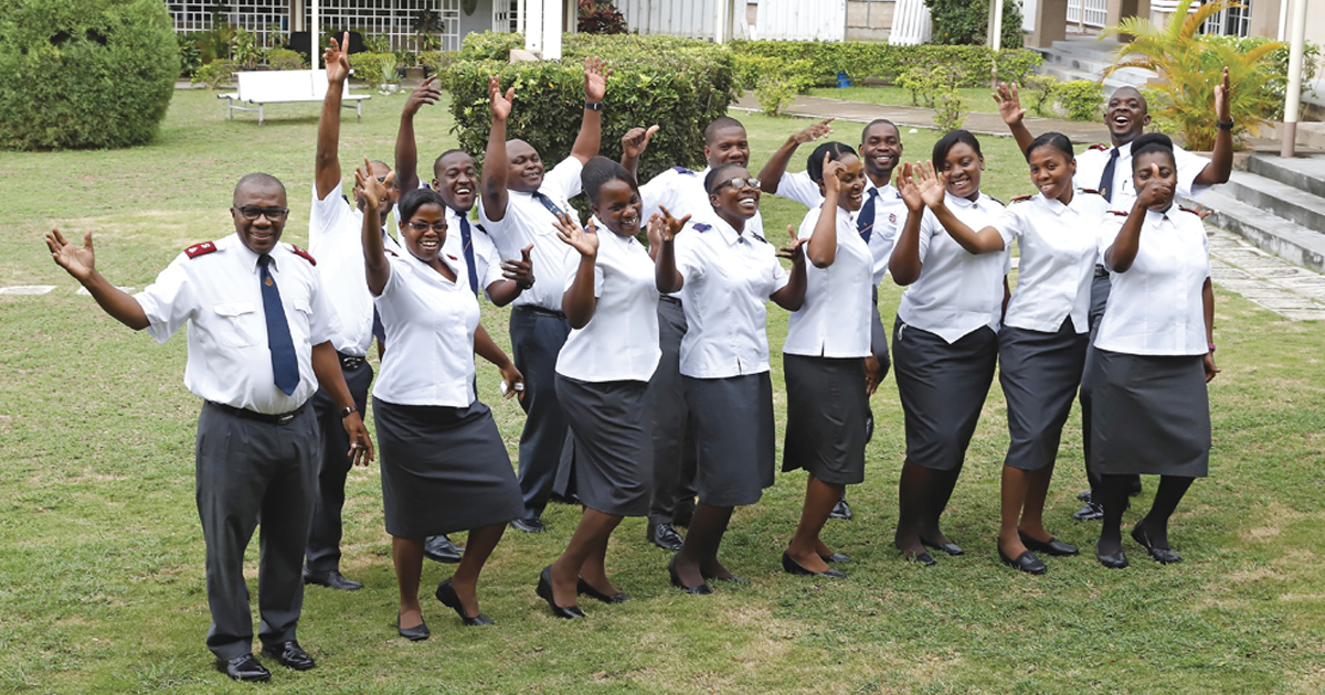 Cadets and officers raise their hands at the training college in Kingston, Jamaica