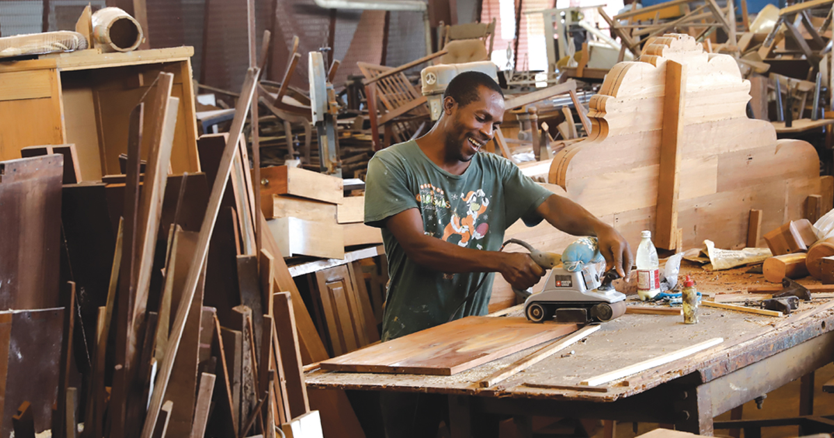 A carpenter fixes furniture in a workshop