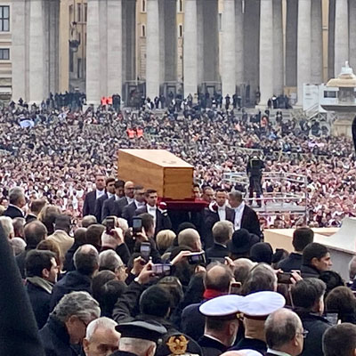 A wooden coffin is carried through St. Peter's Square