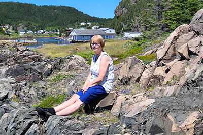 Mjr Judy sits on the beach during a visit to her hometown, Valley Pond, N.L.