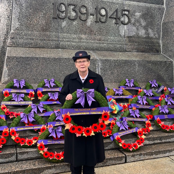 A woman holding a wreath at a war memorial