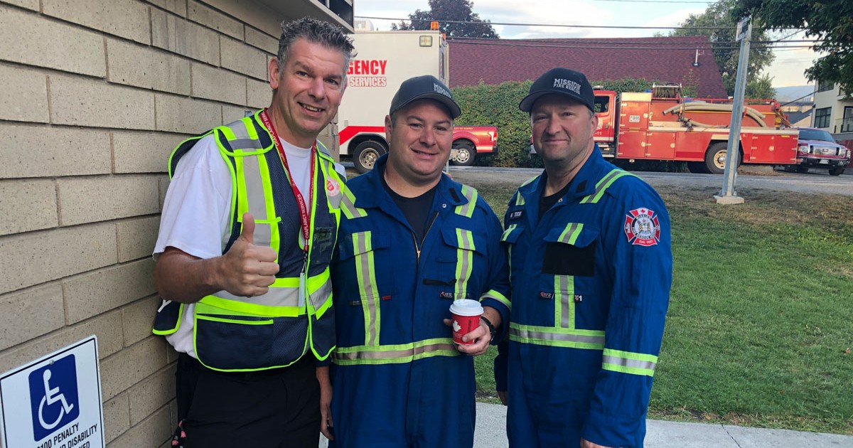 A Salvation Army officer poses with two fire fighters