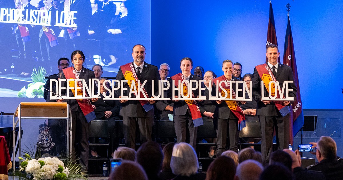 A group of five cadets hold words