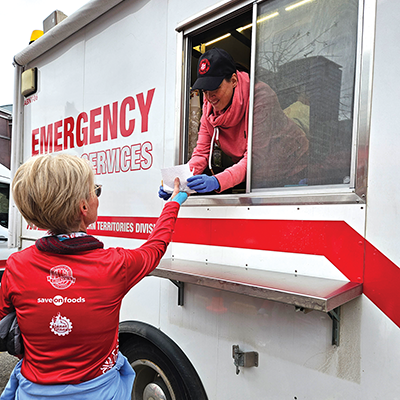 A woman receives some food from a Salvation Army emergency disaster services truck